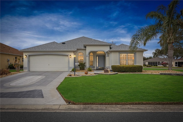 view of front of house with stucco siding, concrete driveway, and a front yard