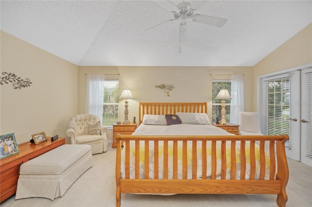 bedroom featuring vaulted ceiling, a textured ceiling, access to exterior, and light colored carpet