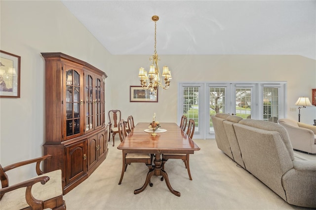 dining room with lofted ceiling, a chandelier, and light colored carpet