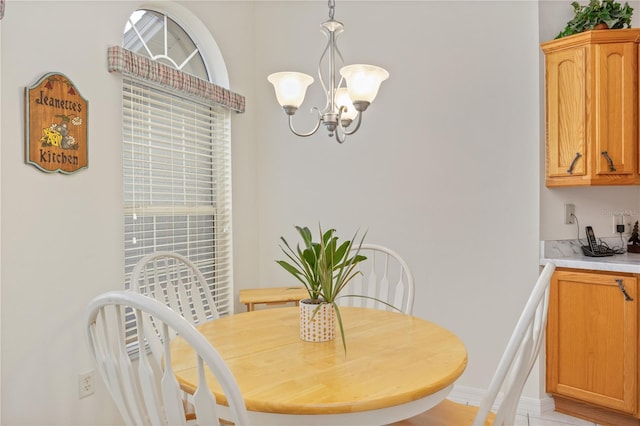 dining space with a chandelier and baseboards