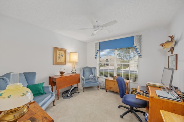 office space with a textured ceiling, ceiling fan, and light colored carpet