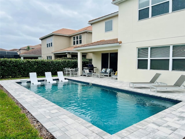 view of pool with a fenced in pool, a patio, an outdoor living space, and grilling area