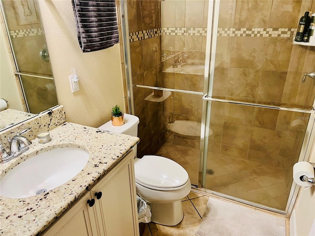 full bath featuring a textured wall, toilet, a shower stall, vanity, and tile patterned flooring