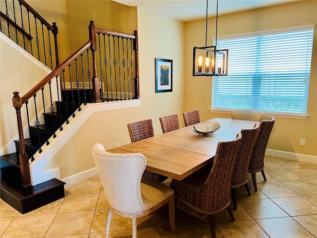 tiled dining area with stairs, an inviting chandelier, and baseboards