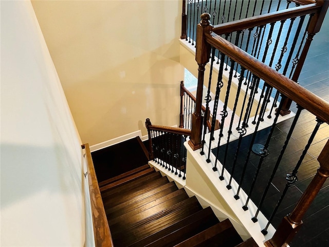 staircase featuring hardwood / wood-style flooring and baseboards