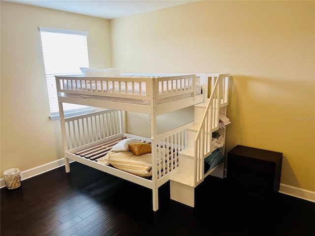 bedroom with wood finished floors and baseboards