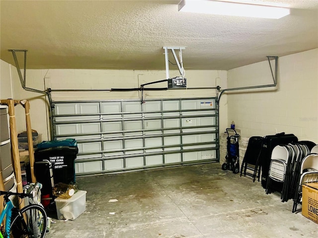 garage with concrete block wall and a garage door opener