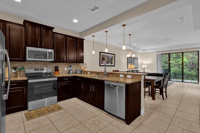 kitchen with stainless steel appliances, a peninsula, a sink, and visible vents