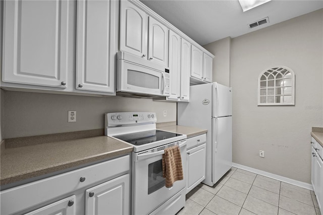 1357 Venezia Ct Unit 402, Davenport, FL 33896 - kitchen featuring light tile patterned floors, white appliances, dark countertops, and white cabinetry
