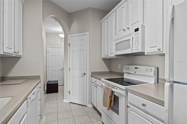 1357 Venezia Ct Unit 402, Davenport, FL 33896 - kitchen featuring arched walkways, light countertops, white appliances, and white cabinetry