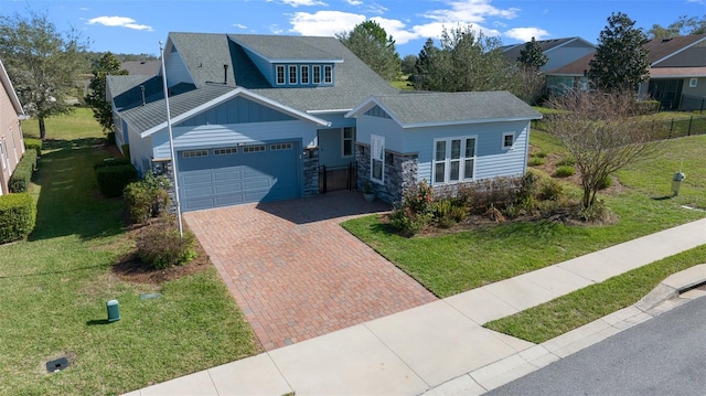 craftsman-style home featuring a garage, board and batten siding, decorative driveway, and a front yard