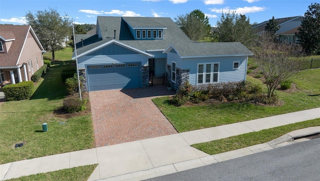 craftsman-style home featuring a garage, stone siding, roof with shingles, decorative driveway, and a front lawn