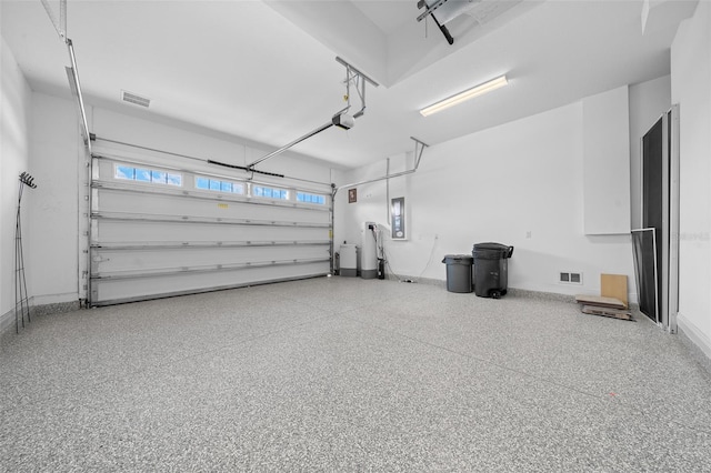 garage with baseboards, electric panel, visible vents, and a garage door opener