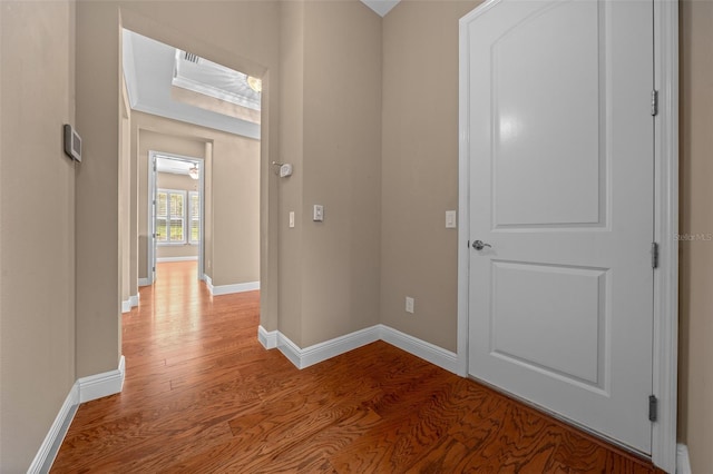 corridor with light wood-type flooring and baseboards