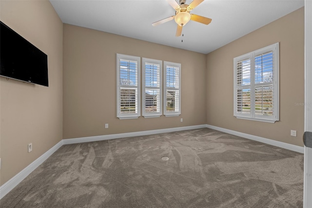 carpeted empty room featuring baseboards and a ceiling fan