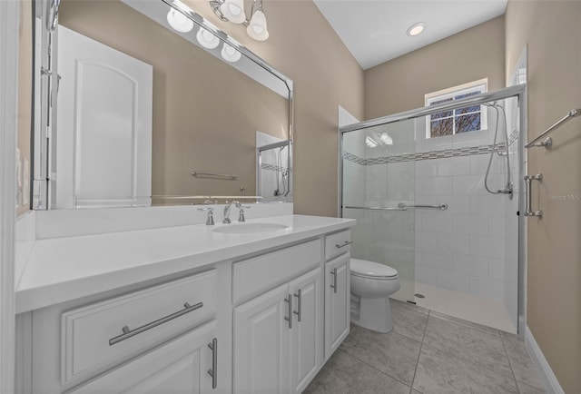 full bathroom with a stall shower, vanity, toilet, and tile patterned floors