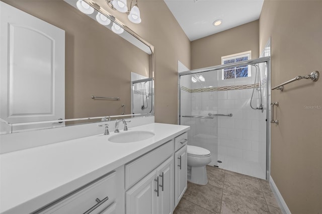 bathroom featuring toilet, a stall shower, vanity, and tile patterned floors