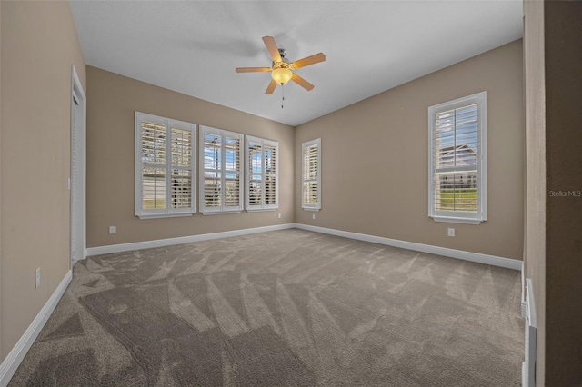 carpeted empty room with a ceiling fan, a healthy amount of sunlight, and baseboards