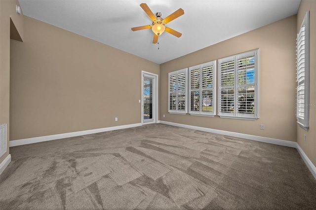 spare room with carpet floors, ceiling fan, and baseboards