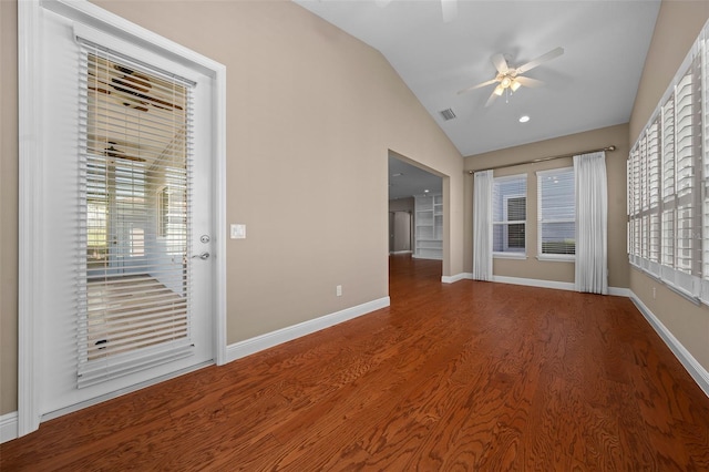 empty room featuring a ceiling fan, lofted ceiling, baseboards, and wood finished floors