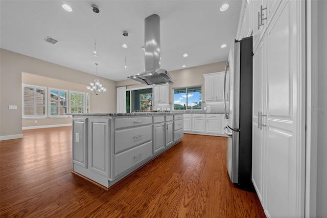 kitchen with dark wood-style floors, stainless steel appliances, white cabinets, a kitchen island, and island range hood