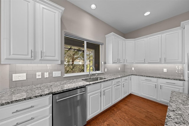 kitchen with tasteful backsplash, dishwasher, light stone counters, white cabinetry, and a sink