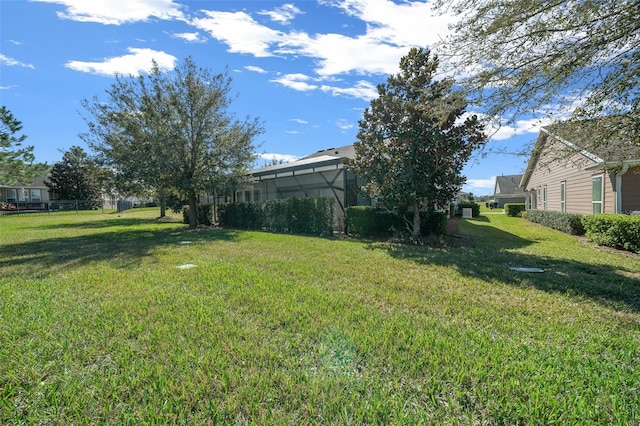 view of yard with a lanai and fence