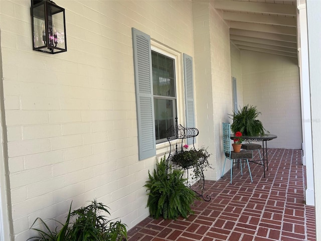 exterior space with concrete block siding and covered porch