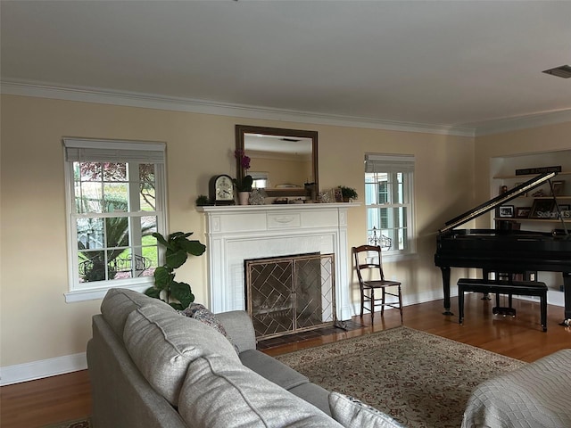 living room with a fireplace with flush hearth, wood finished floors, visible vents, baseboards, and ornamental molding