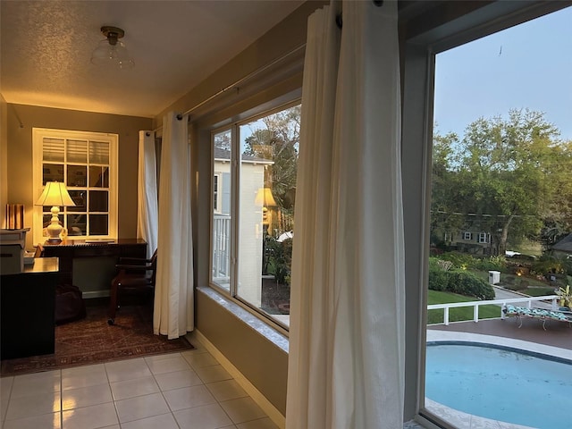 doorway featuring baseboards and light tile patterned floors