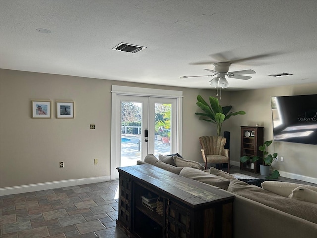 living area featuring baseboards, visible vents, a textured ceiling, and french doors