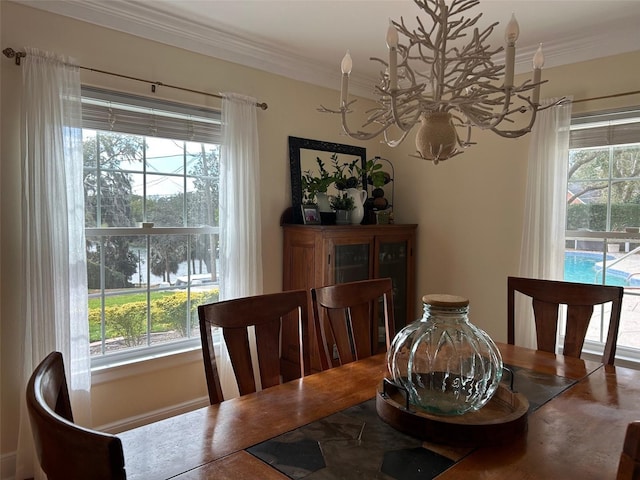 dining space with ornamental molding and a chandelier