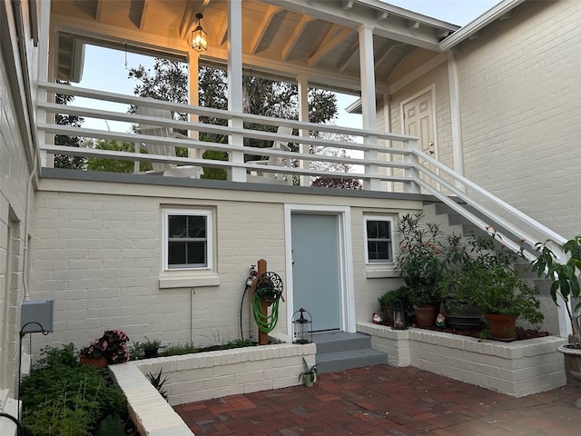 entrance to property featuring brick siding and a balcony