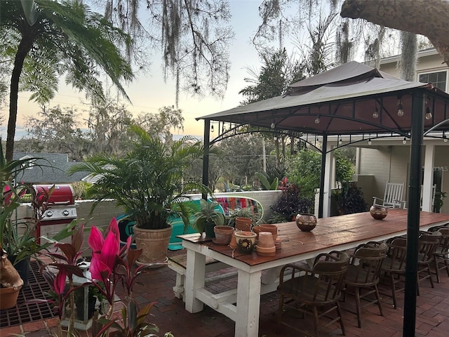 patio terrace at dusk featuring a bar and a gazebo