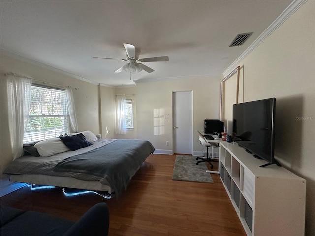 bedroom with ornamental molding, dark wood finished floors, visible vents, and a ceiling fan