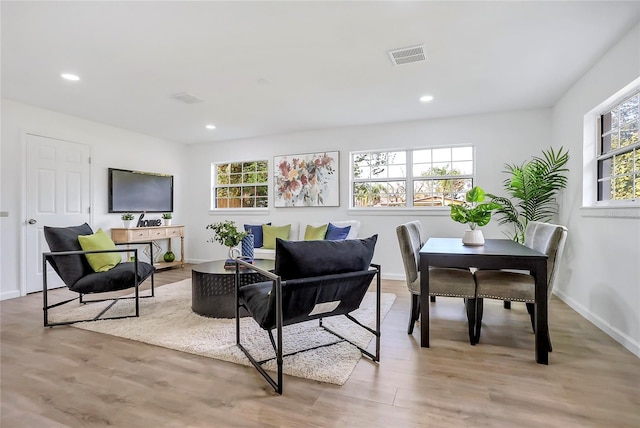 living area with light wood-type flooring, baseboards, visible vents, and recessed lighting