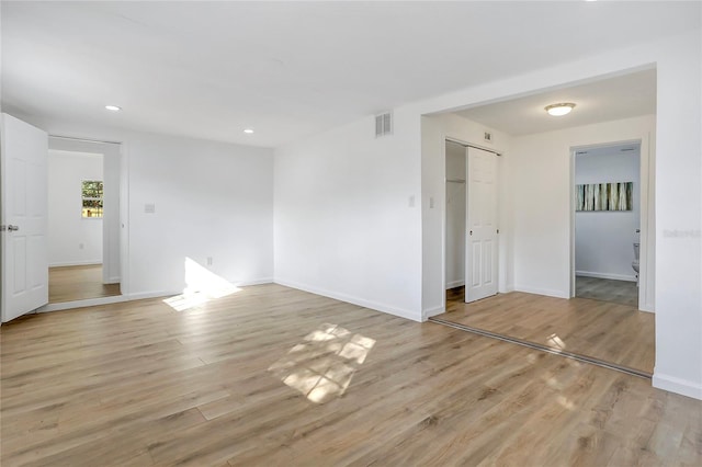 unfurnished room featuring light wood finished floors, baseboards, visible vents, and recessed lighting