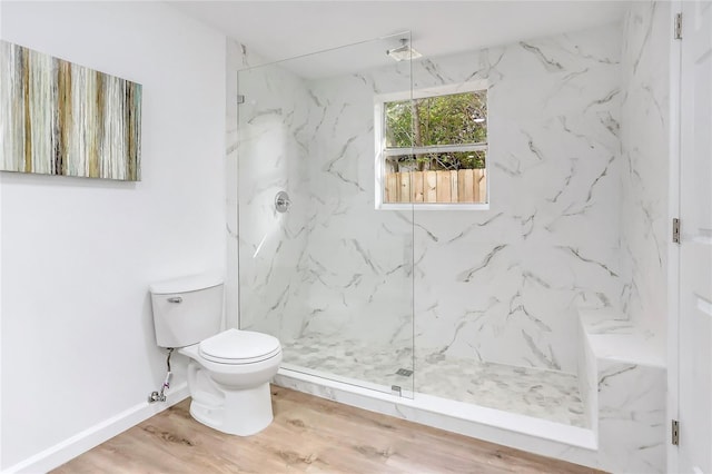 full bath with baseboards, toilet, a marble finish shower, and wood finished floors