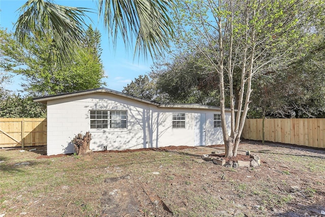 view of front of home featuring concrete block siding and fence