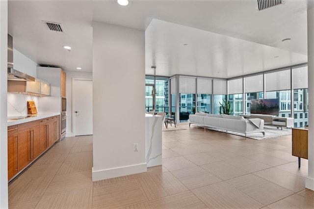 hall featuring light tile patterned floors, visible vents, and recessed lighting