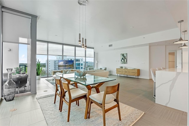 dining room with light tile patterned floors, baseboards, visible vents, and floor to ceiling windows