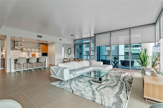 living room featuring a wall of windows and visible vents