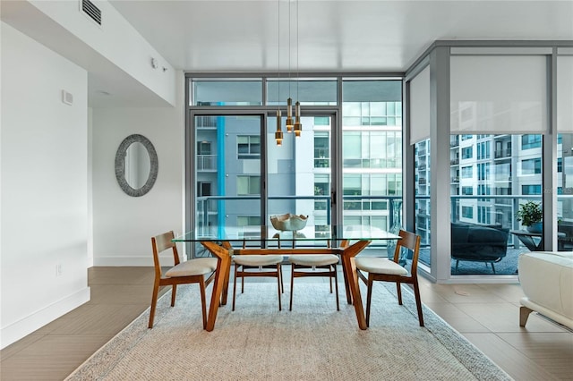 dining space featuring floor to ceiling windows, visible vents, and baseboards