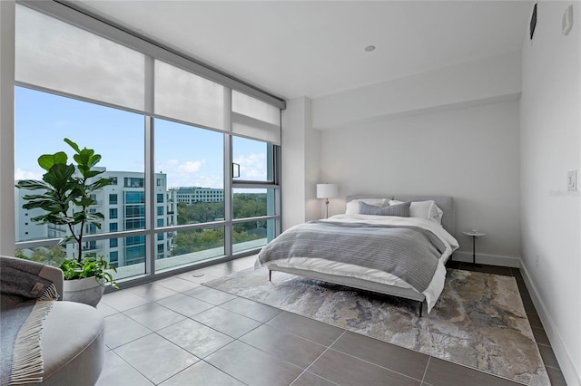 bedroom with baseboards, tile patterned floors, and floor to ceiling windows