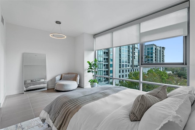 bedroom featuring a wall of windows, tile patterned flooring, visible vents, and baseboards