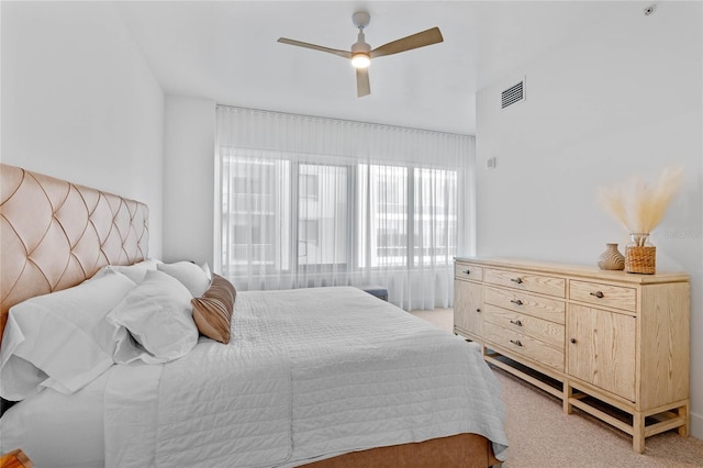 bedroom with light carpet, ceiling fan, and visible vents