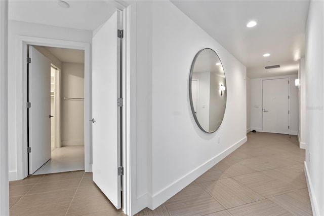 hallway featuring recessed lighting, visible vents, baseboards, and light tile patterned floors