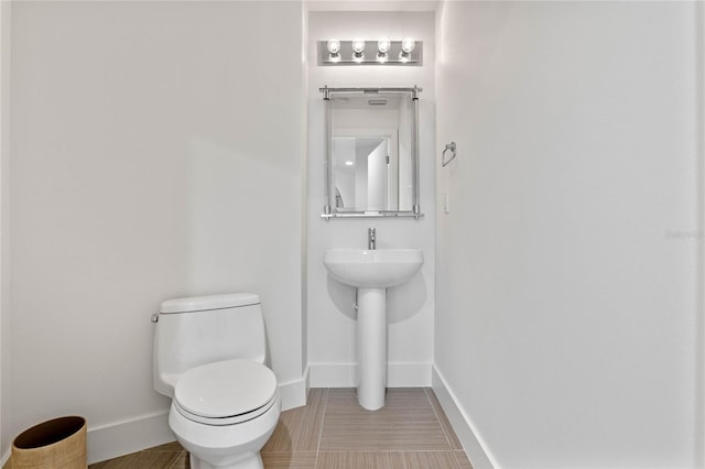 bathroom with toilet and baseboards