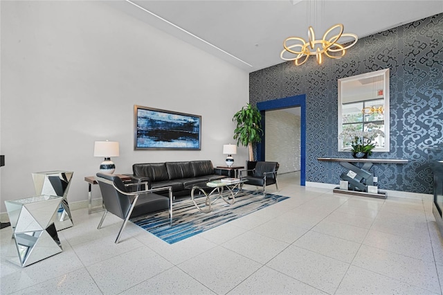 living area featuring baseboards, an inviting chandelier, and wallpapered walls