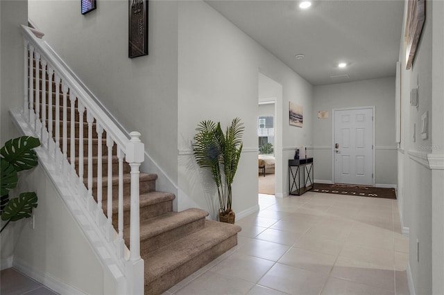 foyer entrance with light tile patterned floors, stairway, baseboards, and recessed lighting